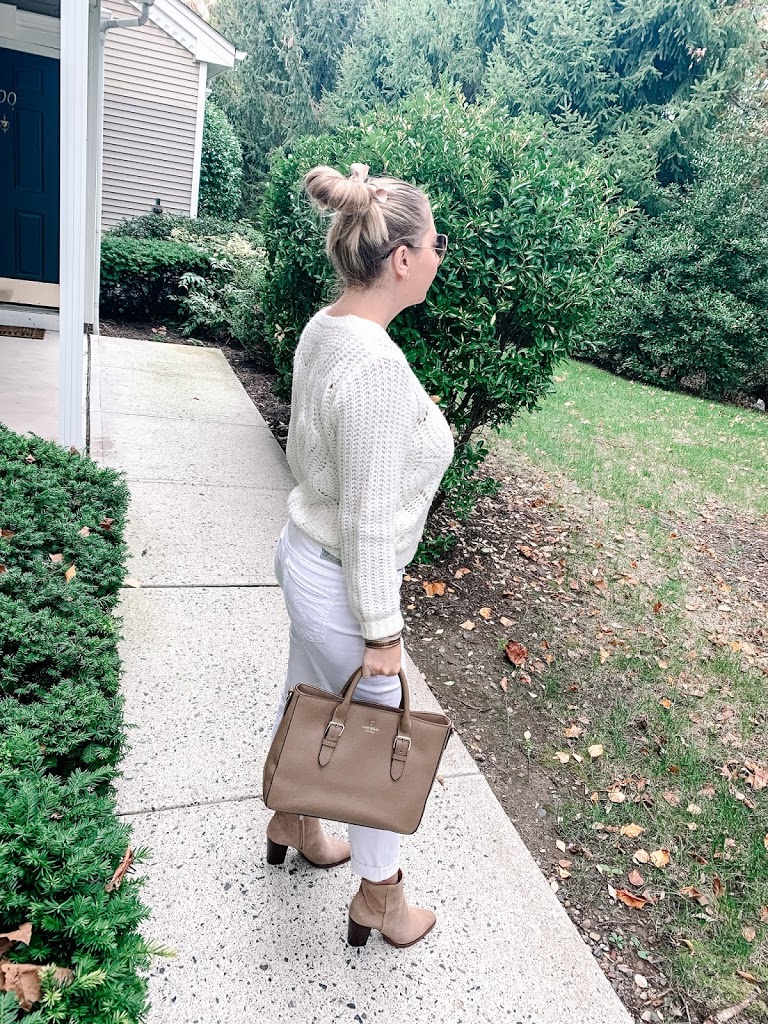 Off-white knot sweater with white jeans, booties, and Kate Spade satchel