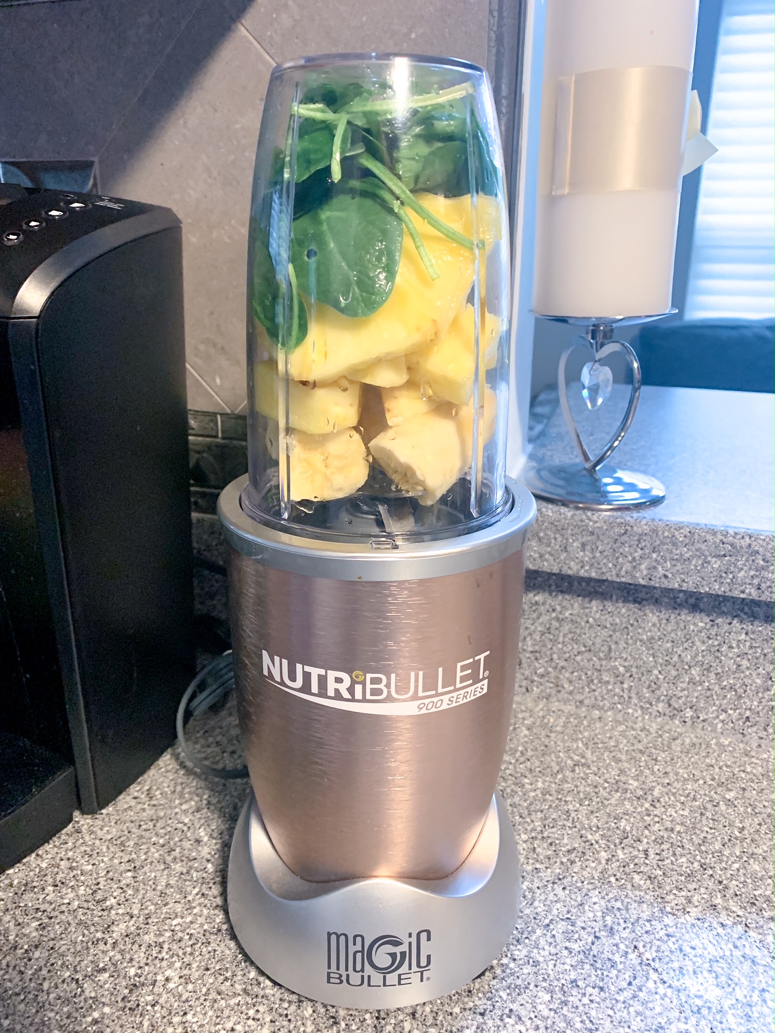 Blending spinach, pineapple and banana in Nutribullet to make a smoothie