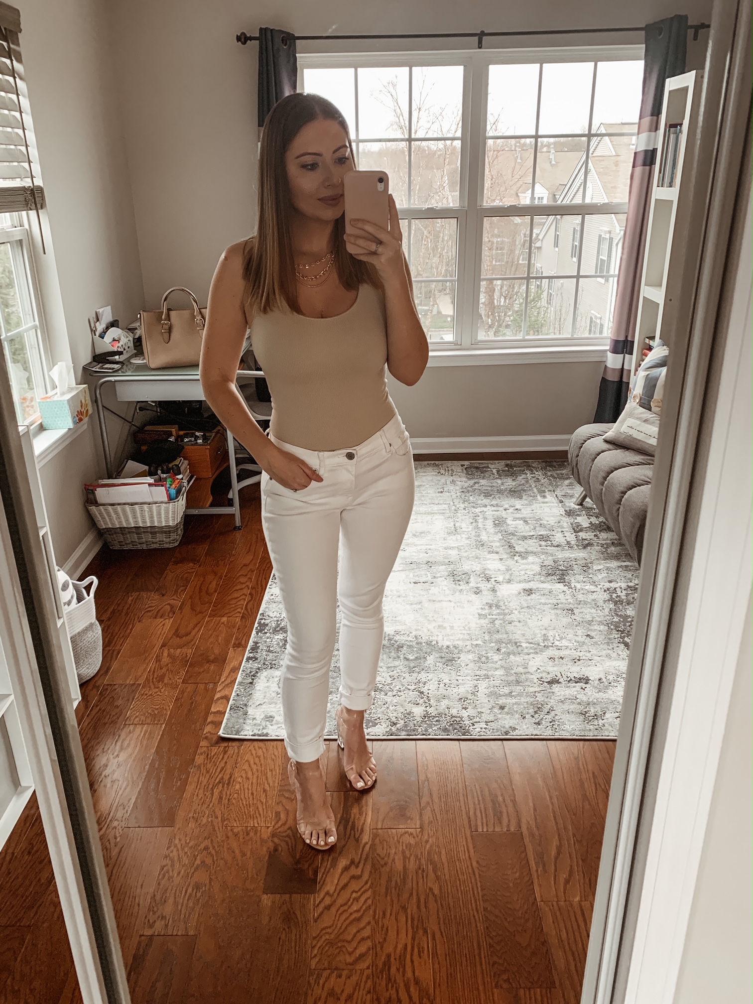 Spring neutral outfit with white skinny jeans, taupe bodysuit, gold chain necklace and clear heels