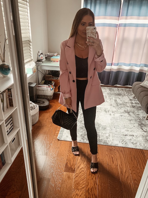 pink blazer with black crop top and black leggings